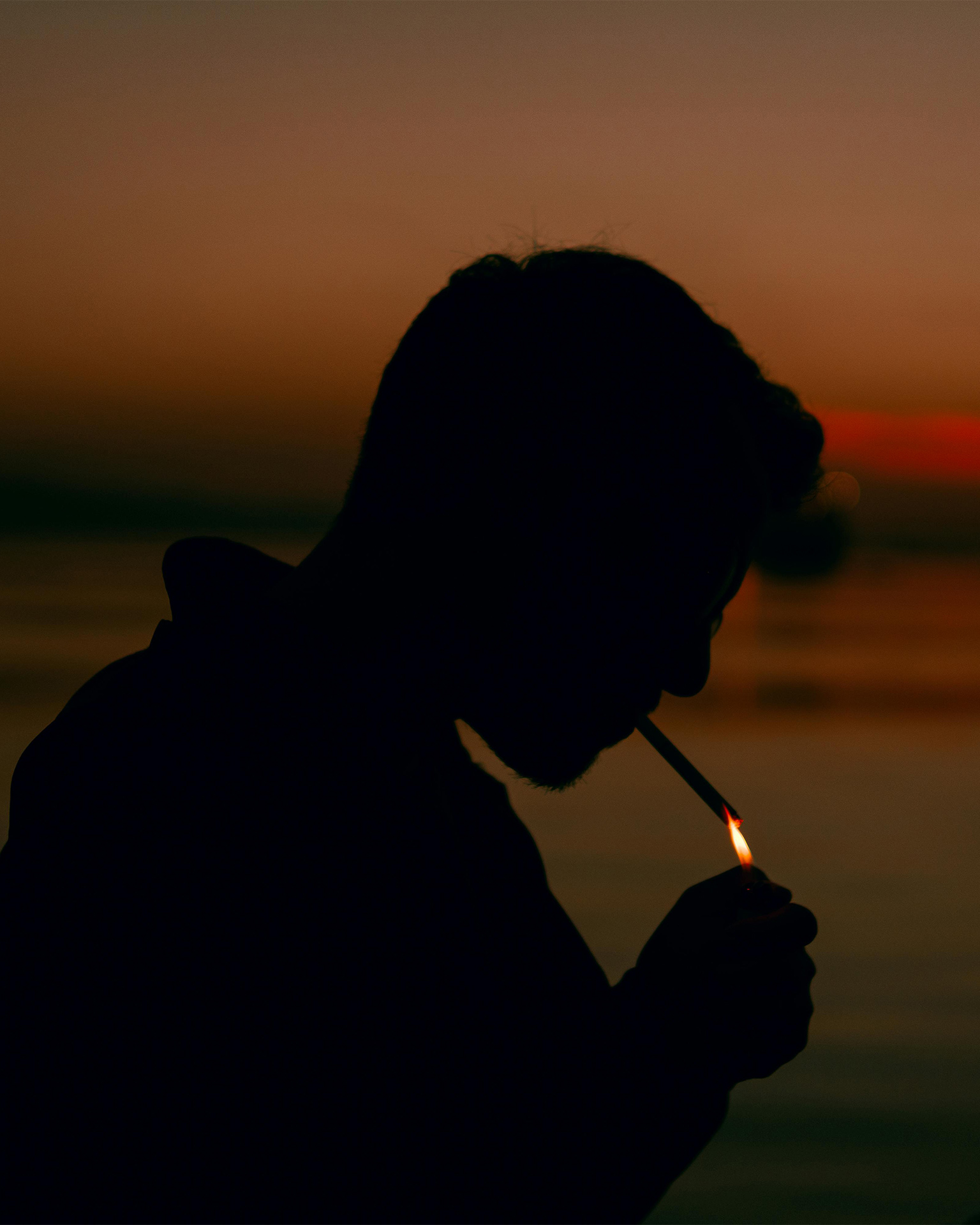 Man smoking silhouette at sunset