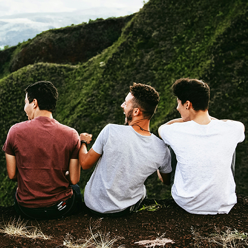 Three friends sitting and looking at a mountain view