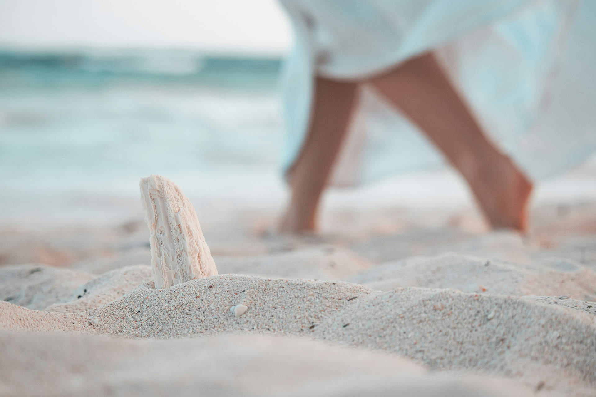 blurred feet of woman walking on a beach