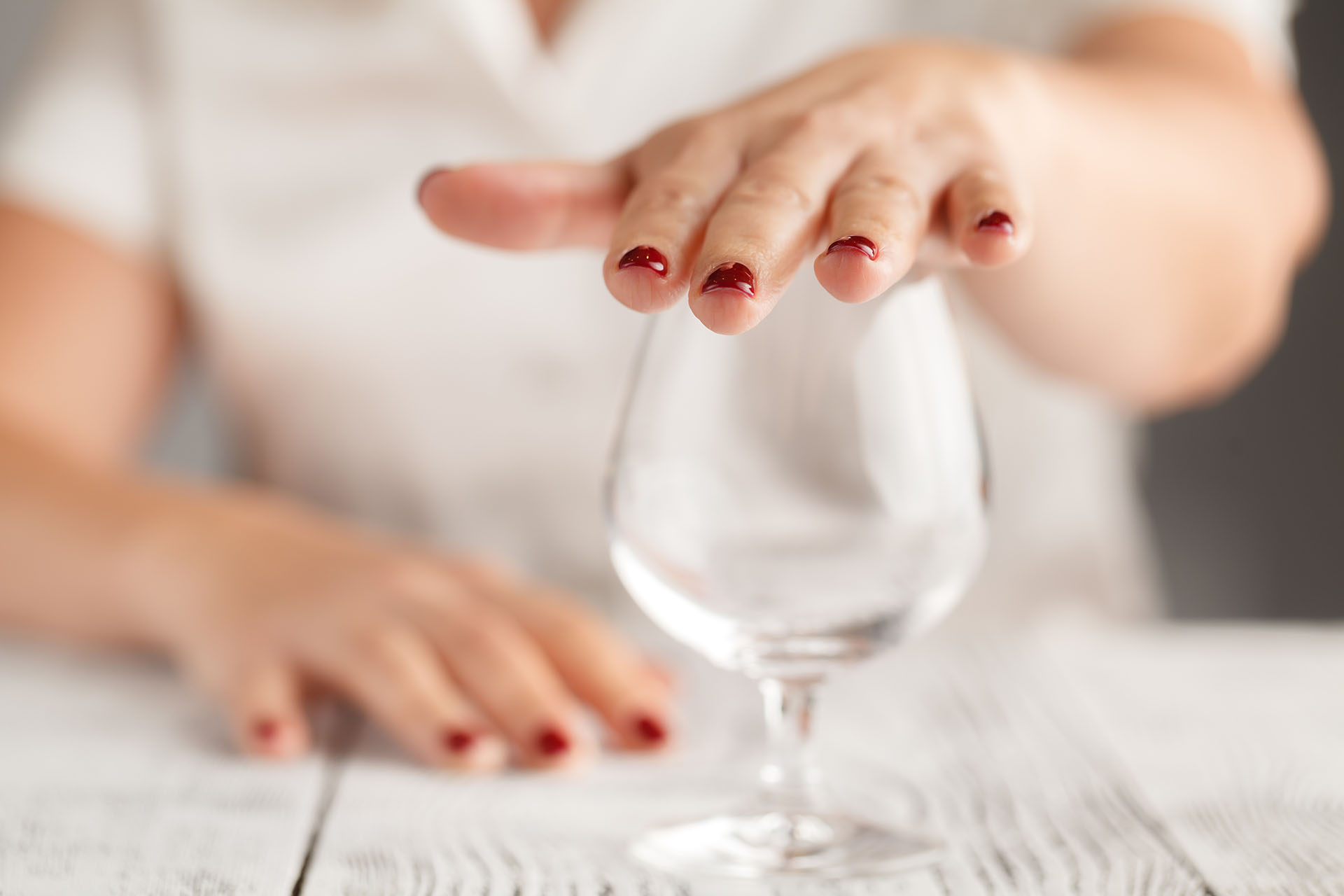 Cropped image of woman showing stop gesture and refusing to drink