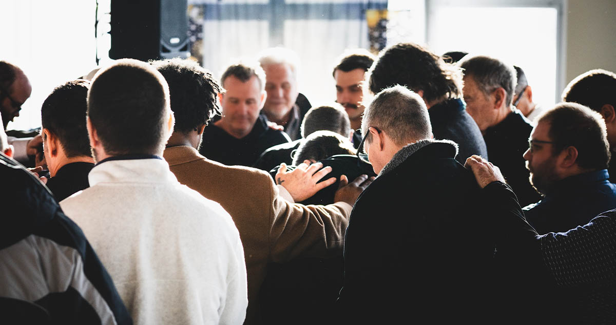 graduation day - crowd laying hands in prayer